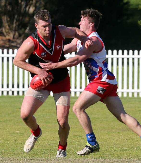 Tough clash: Wollongong Lions defender Stewart Boyd battles with a Bulldogs rival in their top of the table clash. The Lions are away to Kiama in round 17. Picture: ROBERT PEET