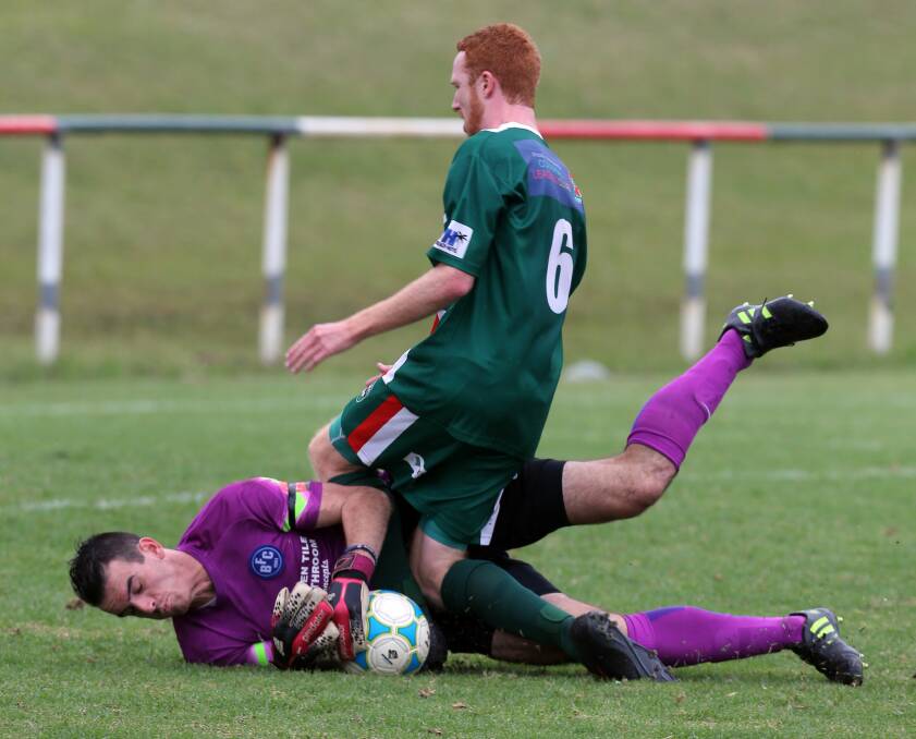 Safe: Bulli goalkeeper Ben McGinnes shows courage diving at the feet of Bellambi’s  Jacob Fryday in the clash at Elizabeth Park. Picture: ROBERT PEET