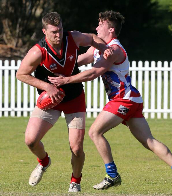 Tough encounter: Wollongong Lions’ Stewart Boyd looks to break a tackle from a Wollongong Bulldogs defender in last Saturday’s clash at Keira Oval. An impressive Bulldogs inflicted the Lions first defeat of the season. Picture: ROBERT PEET

