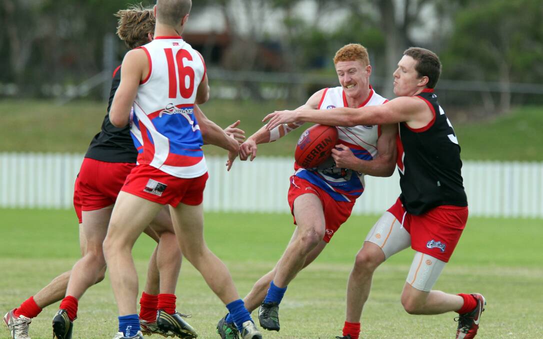 Torrid encounter: Wollongong Bulldogs Ben McKay (centre) tries to make a break in the tough 15 point loss to Wollongong Lions at North Dalton Park. Picture: SYLVIA LIBER