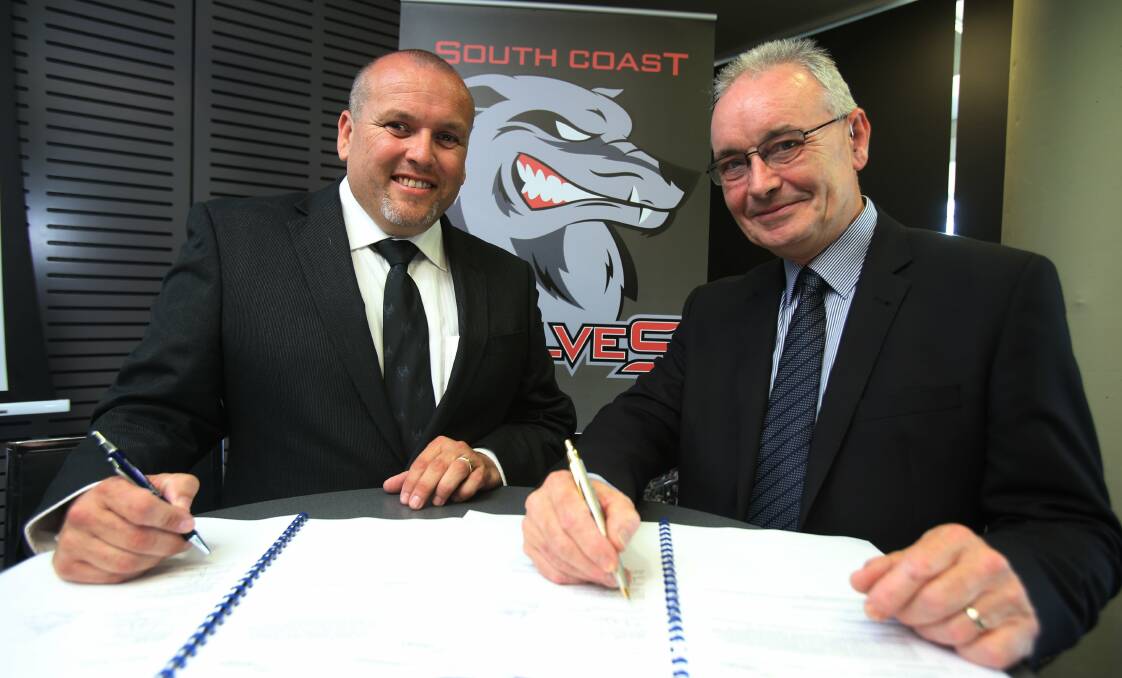 South Coast Wolves chairman Andrew Byron signs the agreement with WIN Stadium general manager Stuart Barnes on Monday. Picture: ROBERT PEET