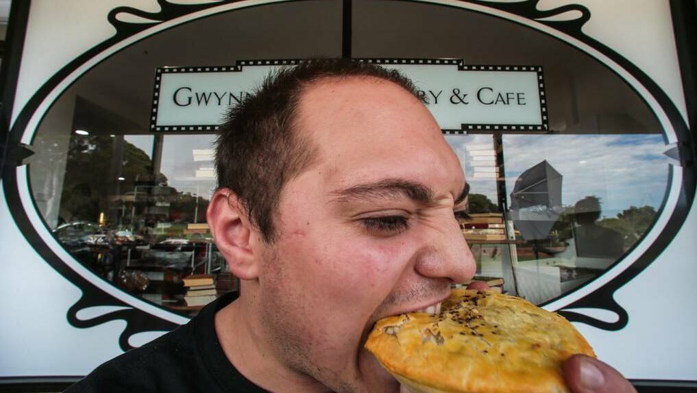 Sam Patrinos of Gwynneville Bakery tucking into a pie. Picture: ADAM McLEAN – The Illawarra Mercury