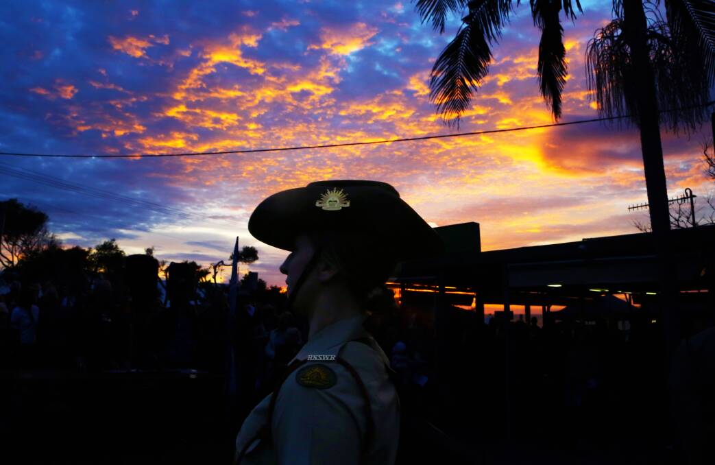 Remembering those who served: Private Tamarra McInerney stayed focused despite being surrounded by a colourful sky at the Coledale dawn service. Picture: Greg Ellis.
