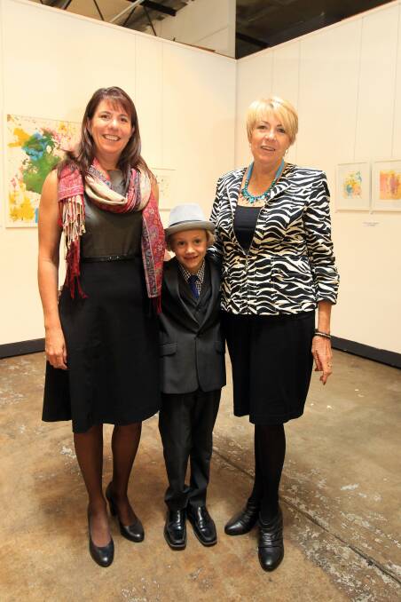 Young artist: Celebrating the art work of Aiden Campbell at his art exhibition is to promote the awareness of kids with learning and memory disabilities at the Project Gallery Wollongong. Simone Campbell, Aiden Campbell and Irene Read. Picture: Sylvia Liber.
