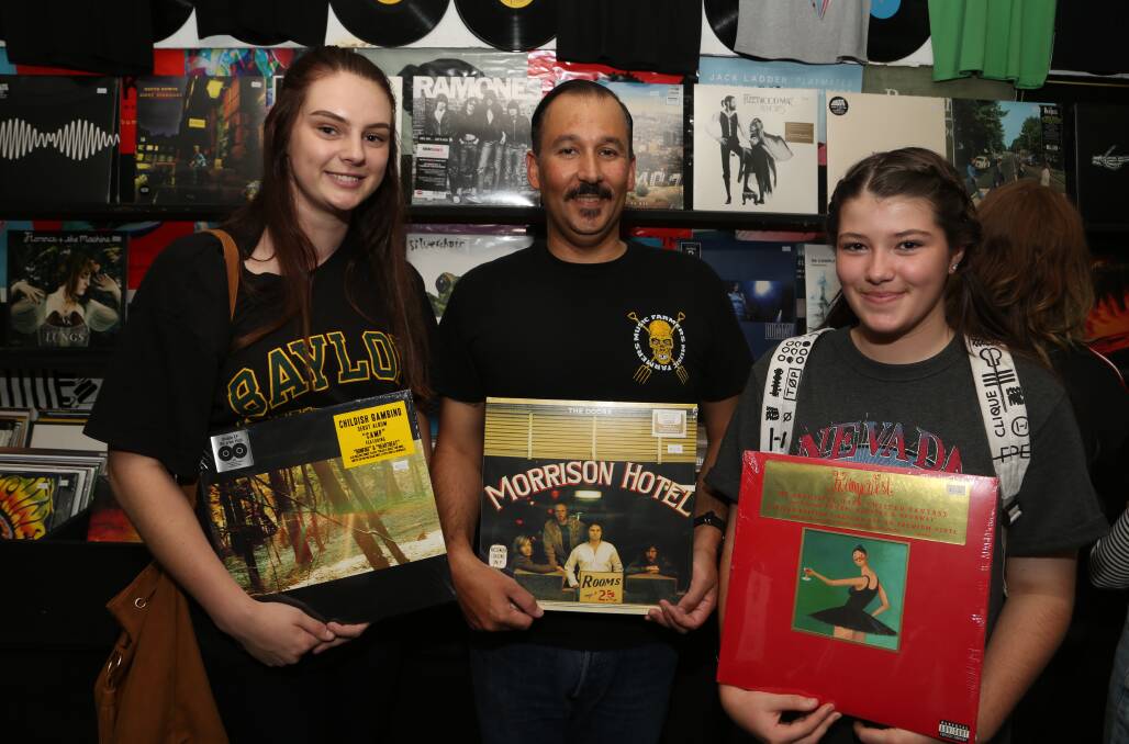 Vinyl heaven: Music enthusiast Jasmine Flood with Music Farmers co-owner Nick Irwin and Jordan Lauchlan. Pictures: Greg Ellis. 