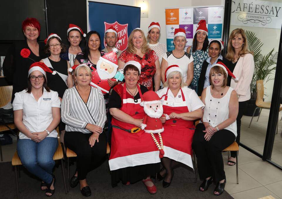 Santa Fun: The Disability Trust's Margaret Biggs and Salvation Army's Karen Walker with red stockings and businesswomen doing some impromptu carols at an Illawarra Women In Business (IWIB) Coffee Club networking function at Cafe Essay. Picture: Greg Ellis.
