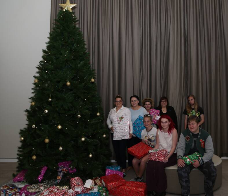 The Fraternity Club at Fairy Meadow starts handing out presents collected from staff, members, directors and guests to people being supported by services run by Southern Youth and Family Services. Picture: Greg Ellis.
