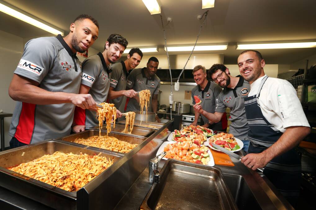 Hawks help out: Demitrius Conger, Cody Ellis, Oscar Forman and Delvon Johnson with Paul Bartlett, Kevin White and Aaron Anderson at the Lighthouse Community Kitchen. Picture: Sylvia Liber. 
