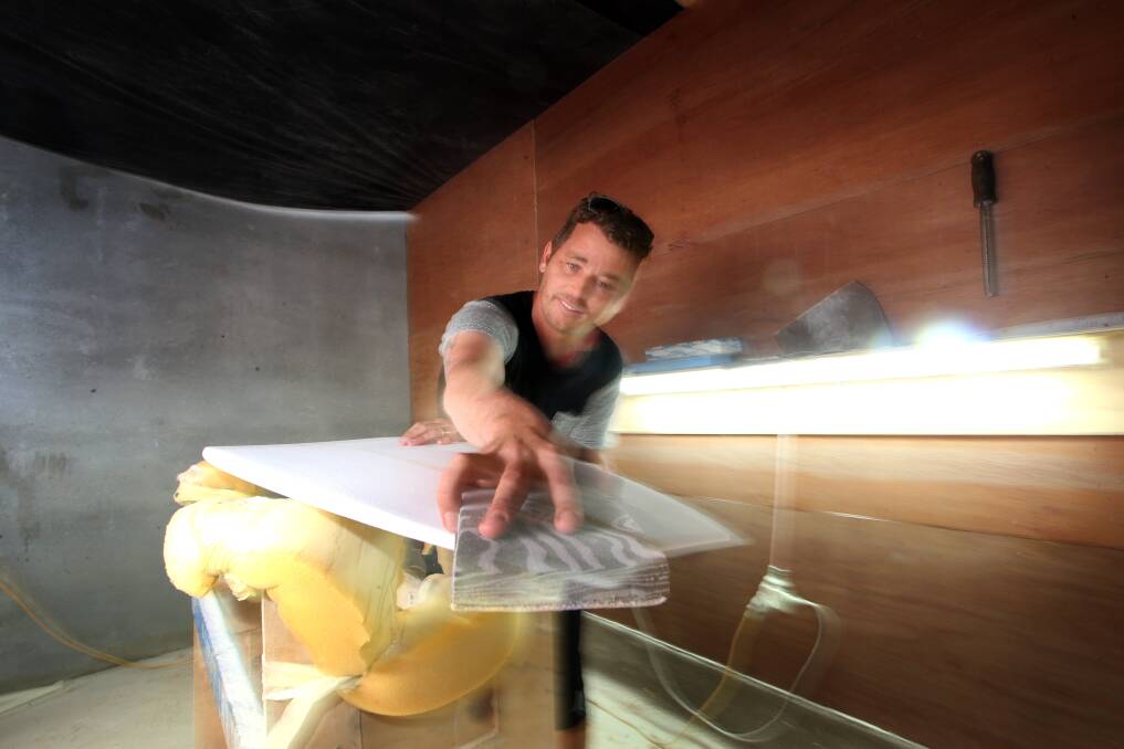 Making waves: Cheyne Lloyd-Sumner works on a new board at Creative Laminating Surfboards' factory in Port Kembla which makes up to 1000 boards a year.

