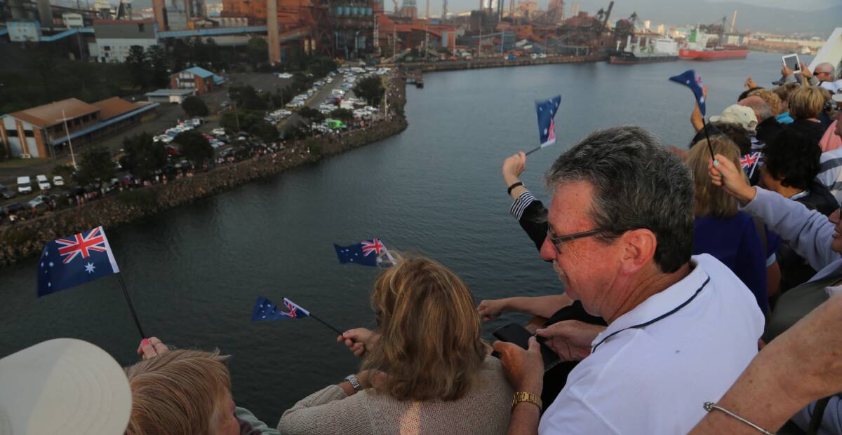Watching you watching me: Passengers waved flags handed out by cruise director Steve Davis to say hi the to thousands of people on the foreshore.

