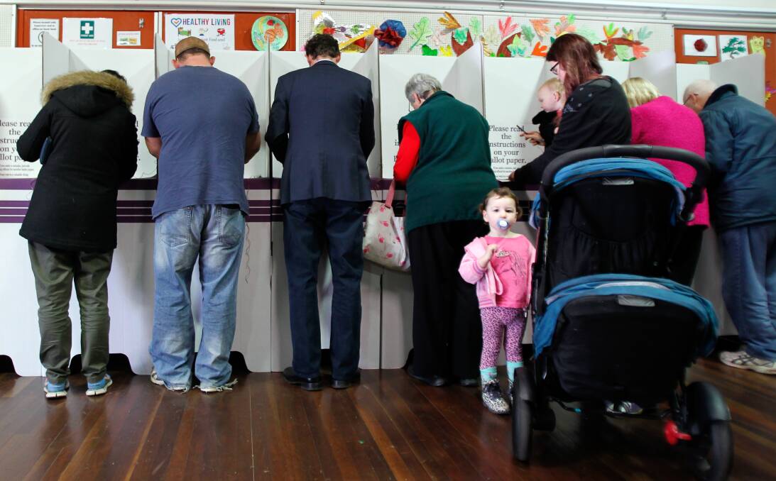 VOTE 1 LABOR: Candidate for Whitlam Stephen Jones, the one in the blue suit, making his vote count among other voters at the Mount Terry Public School on Saturday. Picture: Sylvia Liber.