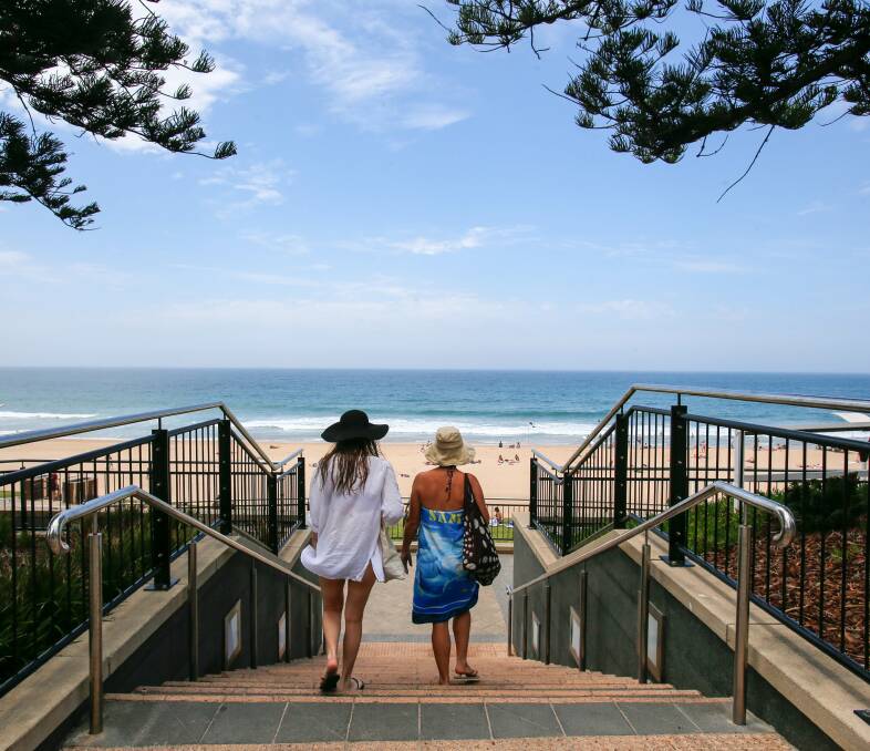 HINT OF SUMMER: Beachgoers head down the stairs at North Wollongong Beach to enjoy the spell of warm spring weather. Picture: Adam McLean