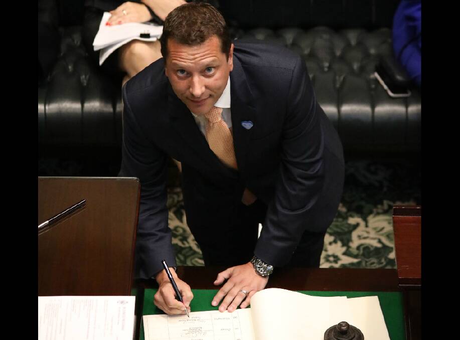 Labor's Paul Scully signs the roll of members during the process of being sworn in as Member for Wollongong in the NSW Parliament on Tuesday. Picture: Supplied
