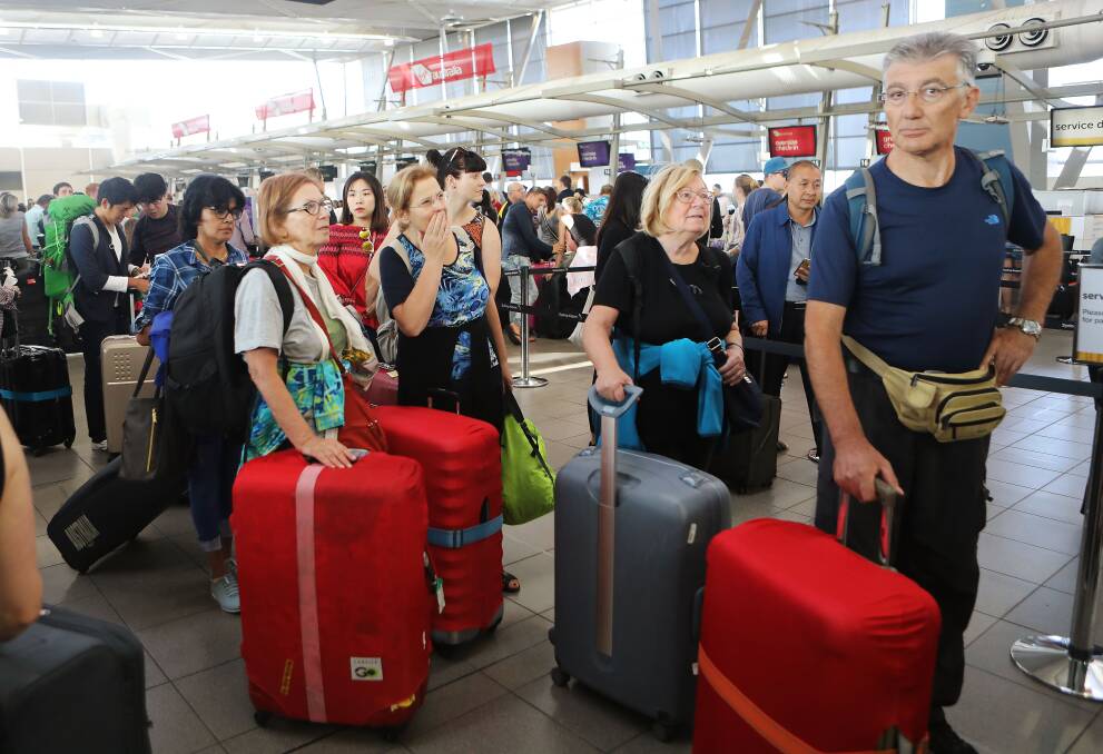 Airline passengers are seen at Sydney Domestic Airport during a technical delay on Monday. Virgin Australia, Qantas and Jetstar have confirmed the problem is affecting flights. Picture: Daniel Munoz / AAP