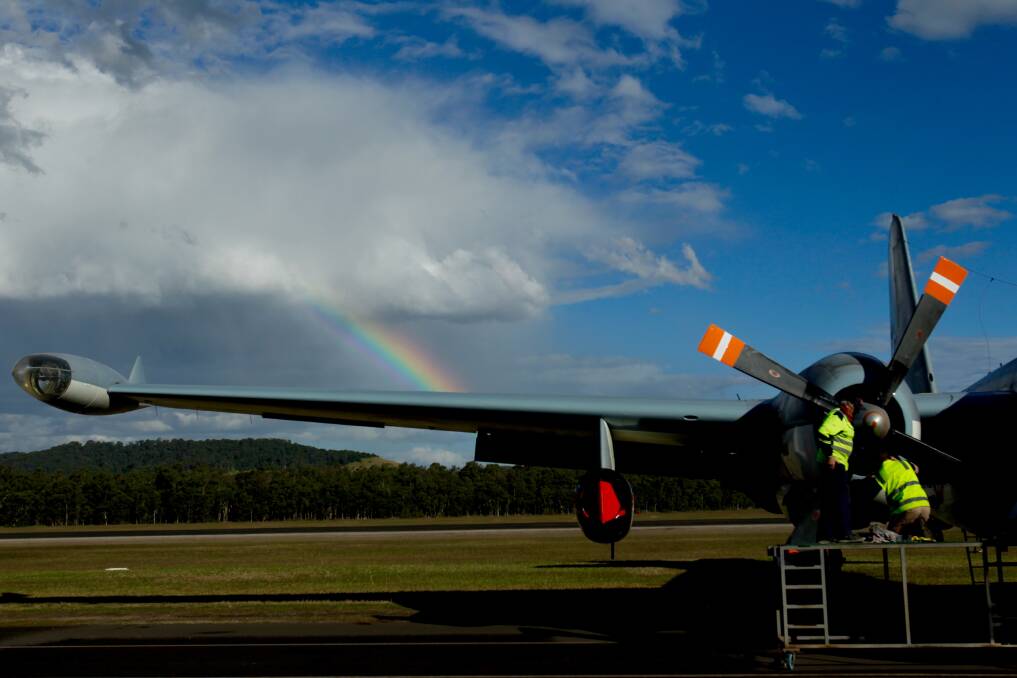 A rainbow appears in the blue sky over Albion Park as maintenance crews tend to an aircraft at the Illawarra Regional Airport on a sunny Sunday. Winter is tipped to be warm and dry, the Bureau of Meteorology says. Picture: Adam McLean 