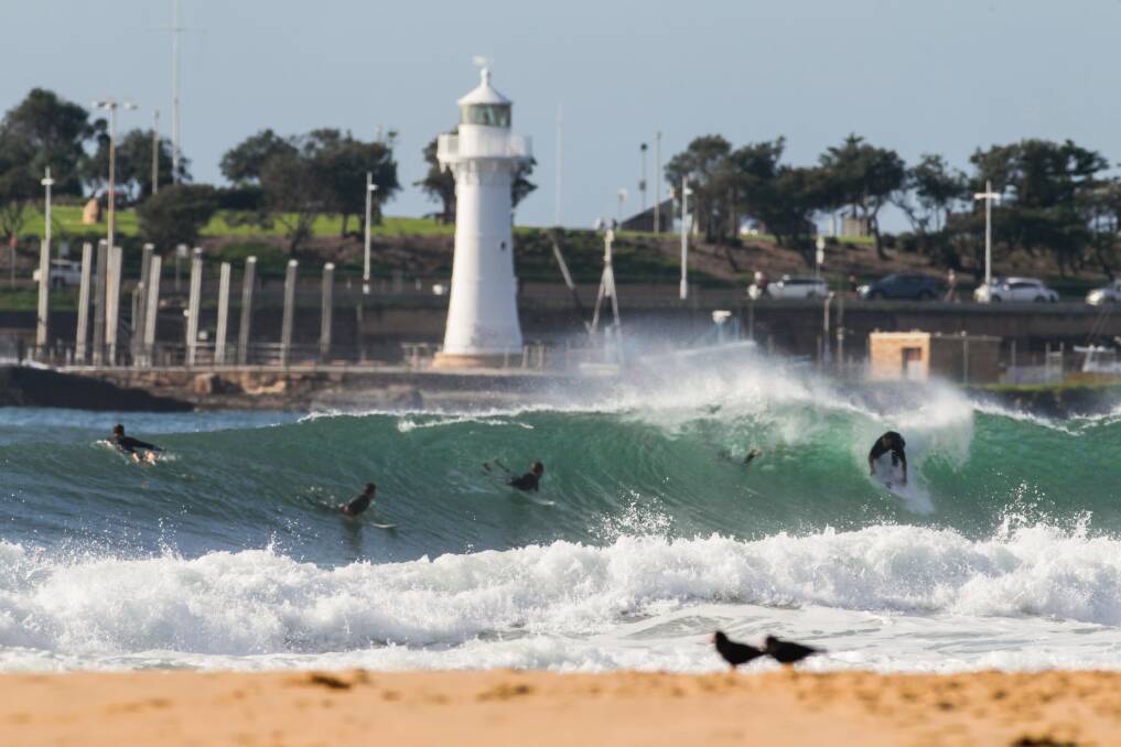 Surfers make the most of the large waves in Wollongong on Saturday. Picture: Georgia Matts