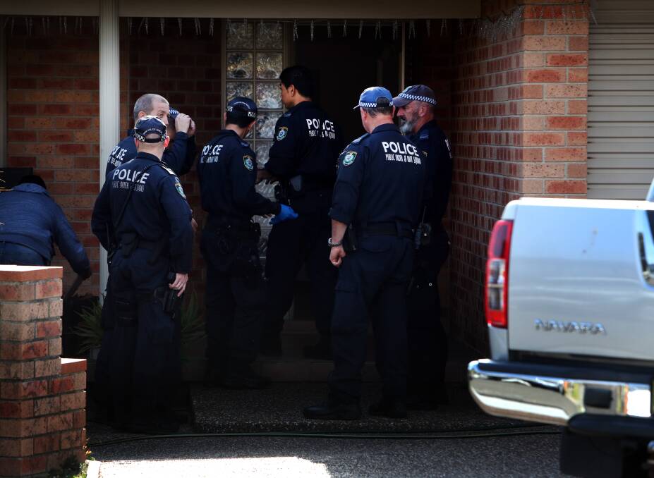 Members of the NSW Police Public Order and Riot Squad outside a home on Edward Street, Barrack Heights on Wednesday, as part of an ongoing police operation.