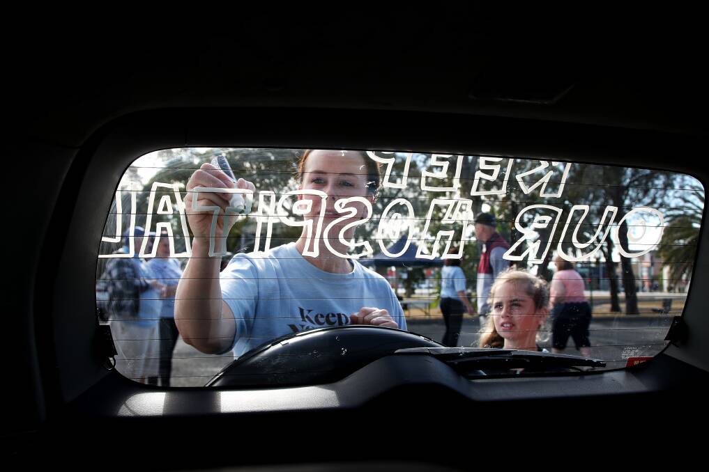 Kaitlyn Newell-Glasser watches on as Shellharbour Hospital nurse Chevonne Cowell chalks a car on Saturday. Picture: Sylvia Liber