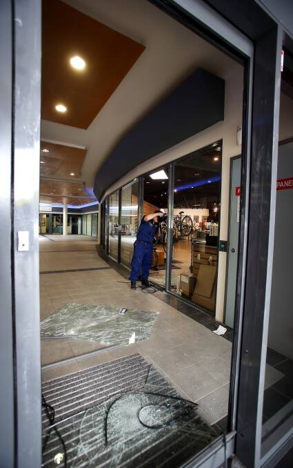 SMASHED: Forensic police collect evidence at Simple Cycles in Shellharbour after a break-in, described by the manager as a "smash and grab" on Friday morning. 
