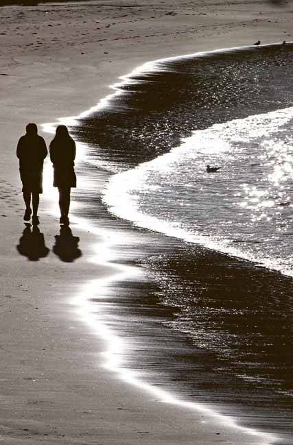 Chris Walker and his sister Bianca rug up as they walk along the harbour foreshore. Picture: KIRK GILMOUR