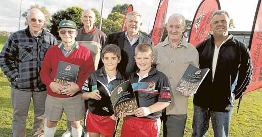 Launching Corrimal Rugby League Club's centenary book are ex-players and players (from left) George Evans, Dennis Murada, Norm Jarvis, Isaac Morris, 9, author Barry Ross, Cooper Gould, 9, John Raper and John Jansen. Picture: ANDY ZAKELI