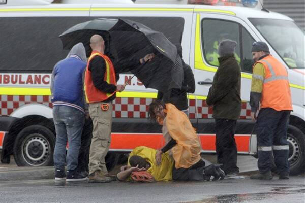 Paramedics treat a cyclist hit by a car in Wollongong this afternoon. Photo: ANDY ZAKELI