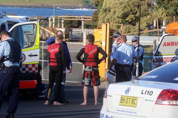 Two jet-skiers who retrieved a drowned man from waters off Port Kembla speak with police after the incident. 
