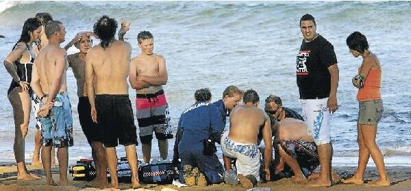 Paramedics perform CPR on a man dragged unconscious from the surf at Austinmer Beach on Thursday.  Picture: KIRK GILMOUR