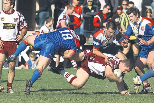Derek Gray is brought down by defenders from Gerringong yesterday. The Lions are through to the grand final. Pictures: KEN ROBERTSON