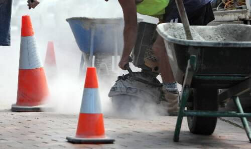 Contractors cut holes in the path along Atchison St near the Australian Tax Office last week  in preparation for the city's new parking meters. Picture: ANDY ZAKELI