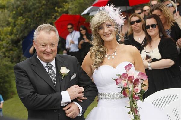 Erin walks down the aisle with her father Chris Graham;