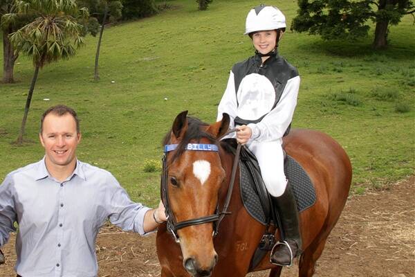 Horse trainer Peter Lord and daughter Molly on her horse Billy at their Thirroul home.