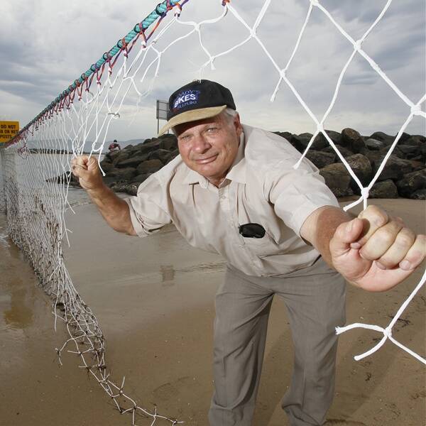 Lake Illawarra Authority construction manager Claude Domio inspects the damaged shark net at Reddall Reserve. Picture: DAVE TEASE
