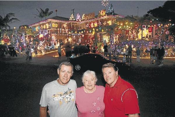 Craig Hughes (right), with mum Joyce and helper Rick Dawes outside the Christmas lights display in Cuthbert Dr, Mt Warrigal. Picture: DAVE TEASE