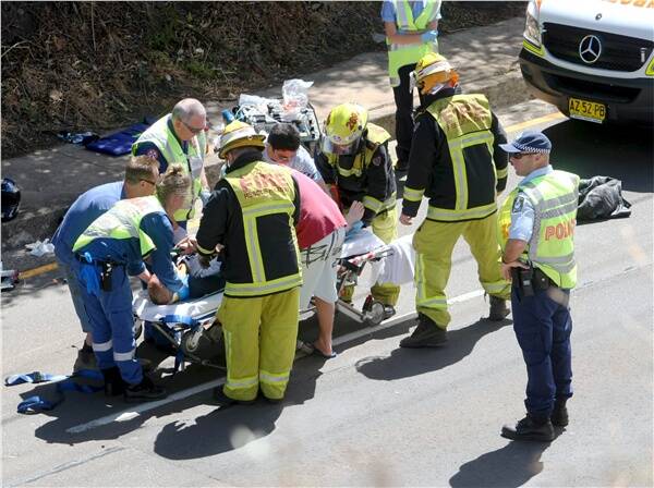 Ambulance officers treat a patient at the scene of the crash. Picture: DAVE TEASE