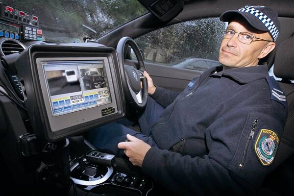 Wollongong highway patrol’s Senior Constable Phil Roddy demonstrates the automatic number plate recognition technology. 