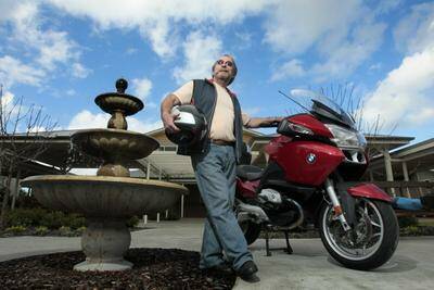 Volunteer Dennis Woodward's BMW 1200 motorbike has caught the attention of young men with dementia. Photo: DAVID TEASE