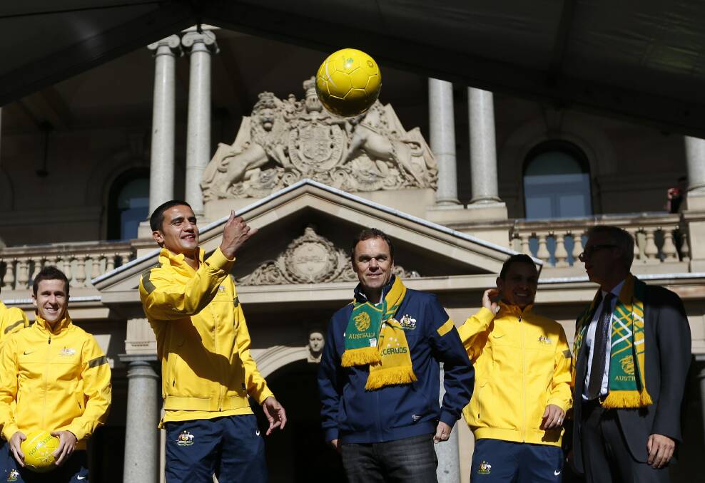 Tim Cahill throws a ball to the crowd during the Socceroos’ celebration of making the World Cup. Picture: REUTERS