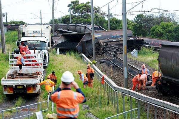 Workers at the scene of yesterday's coal train derailment on the South Coast line at Clifton. Picture: KIRK GILMOUR