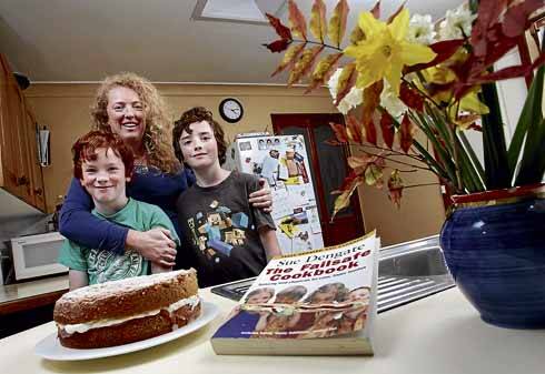 Keiraville mum Rowena Morris with children Liam, 8, and Kai, 10, and a "fail safe" additive-free pear cake. Ms Morris says a book on the effects of food additives by Sue Dengate has changed her family's life. Picture: KEN ROBERTSON