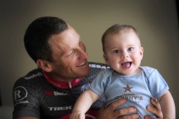Seven-time Tour de France winner Lance Armstrong with his eight-month-old son Max in 2010. Picture: David Mariuz