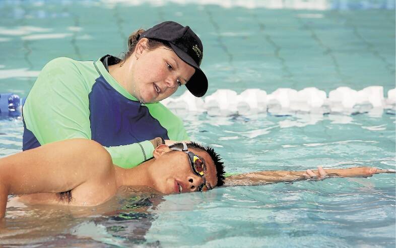 Instructor Erin Faricy guides University of Wollongong student Jichao "Jimmy" Zhang, who is improving his freestyle swimming. Picture: ROBERT PEET