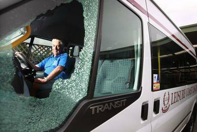 Leisure Coast Limousines owner Mike Horsley with the damaged window after his bus was attacked at Warrawong. Picture: SYLVIA LIBER