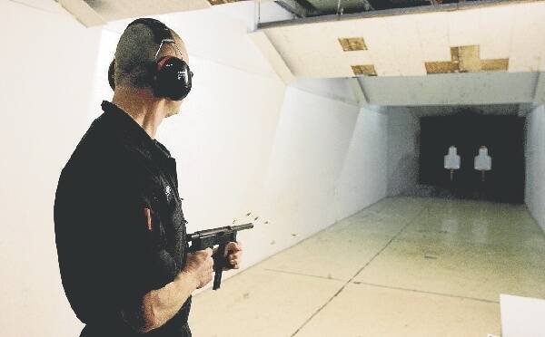 A police officer fires a machine gun. Two machine guns were purchased by detectives posing as weapons buyers.