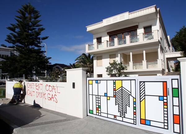 A worker cleans graffiti from the wall of the Wollongong mansion owned by Arun Jagatramka. Picture: KIRK GILMOUR 