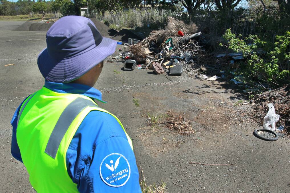A Wollongong council ranger in front of an illegal dumping site at Kembla Grange. Picture: ORLANDO CHIODO