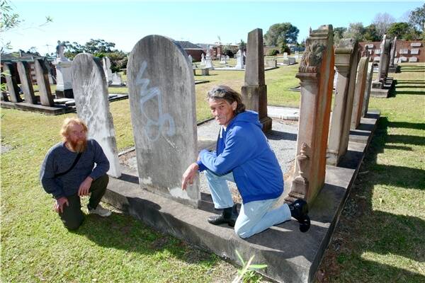 Bulli residents Robert Miller and Theo Happel survey the damage at St Augustine's Anglican Cemetery. Pictures: DAVE TEASE