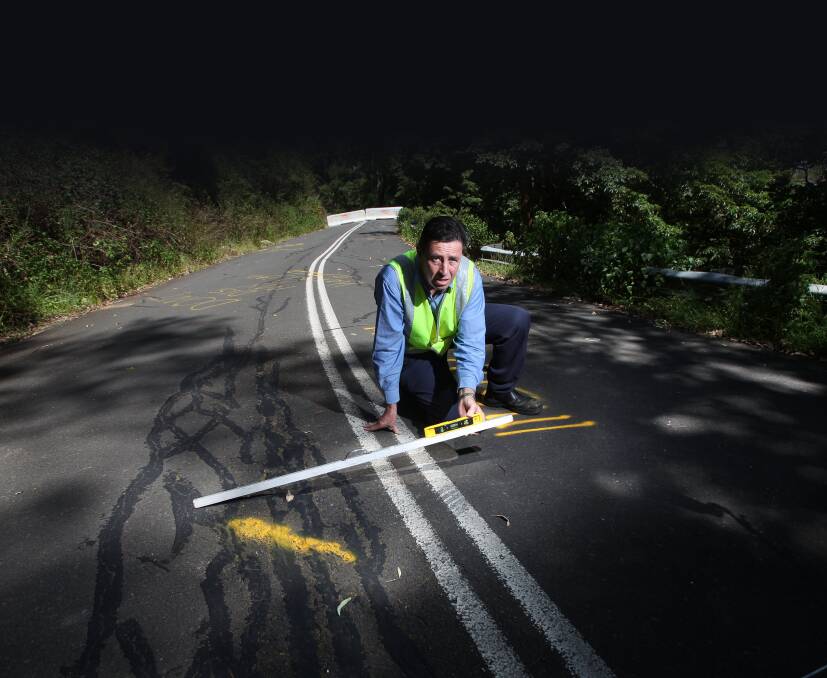 Wollongong City Council geotechnical officer Peter Tobin shows the subsidence at Mt Keira Road. Picture: KEN ROBERTSON