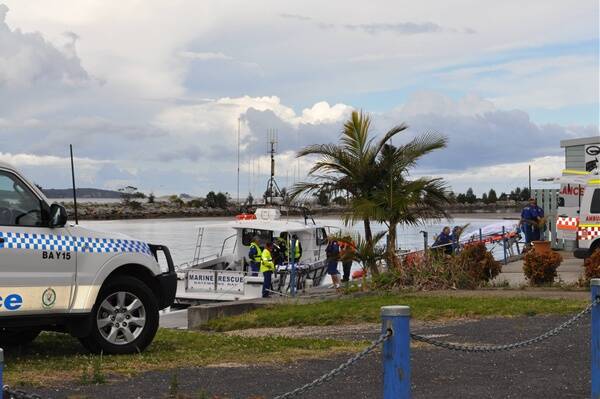 A body is removed from a police boat after a triple boating tragedy at Batemans Bay. One man is still missing. PHOTO: Kim Treasure.