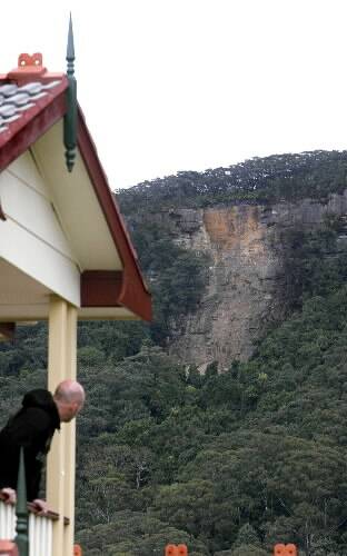 Scarborough resident Ben van Loo checks out a landslide caused by overnight heavy rains on the Illawarra escarpment above the northern suburb villages of Wombarra and Scarborough.  Picture: KIRK GILMOUR